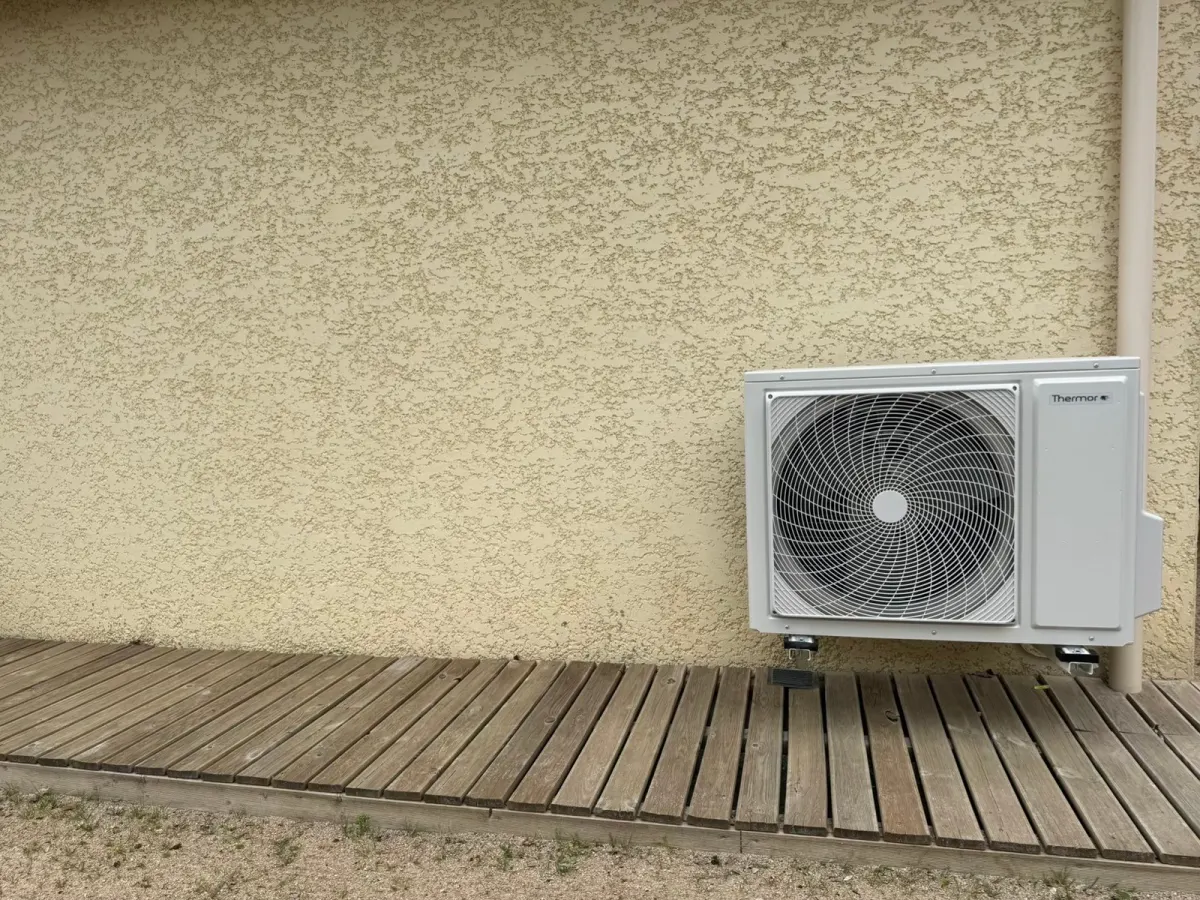 Unité extérieure de climatisation Thermor posée sur une terrasse en bois
